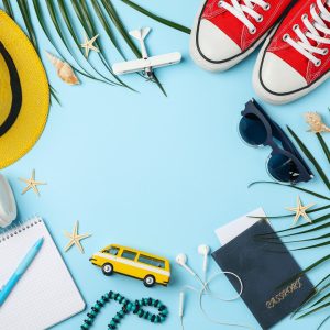 Travel accessories on blue background, top view. Travel blogger